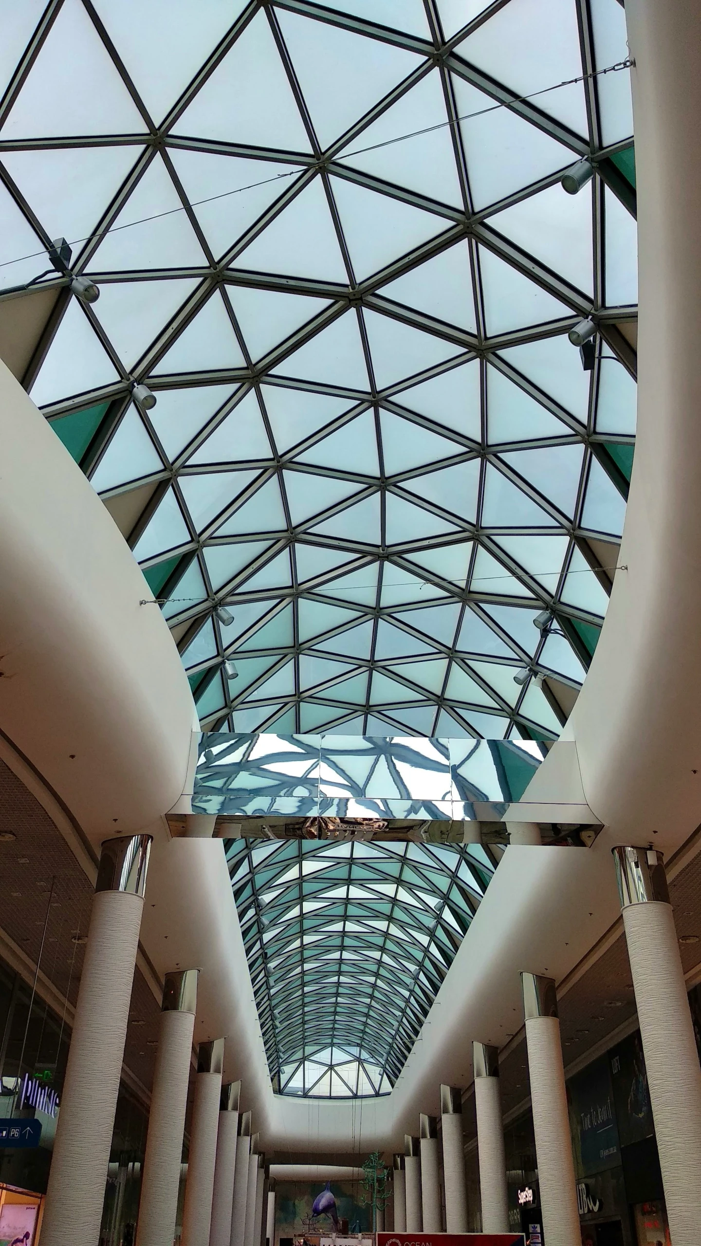 the inside of a mall with a large glass ceiling