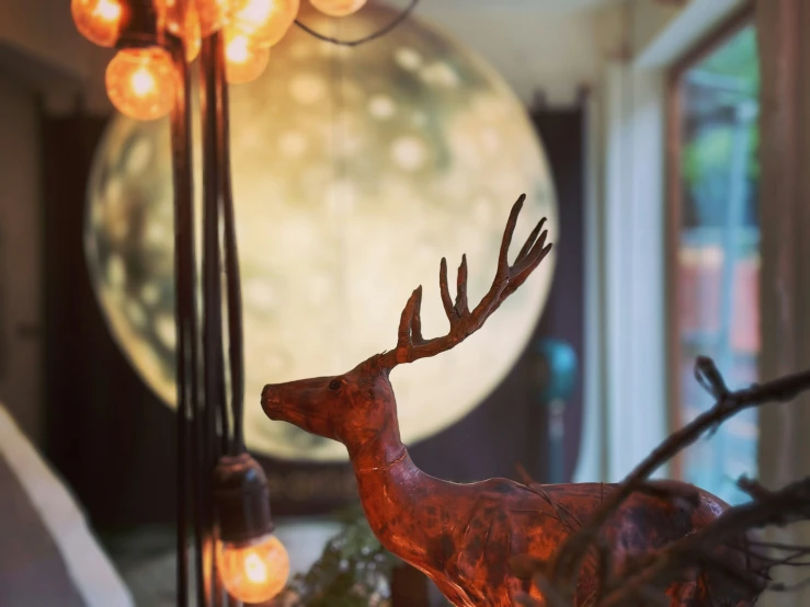 a deer statue standing next to a light on the ceiling