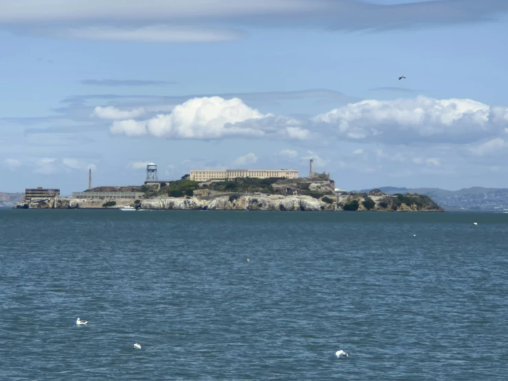 a big building with a tower on top of it sitting in the middle of the ocean