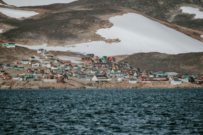 a small town with red houses next to the water