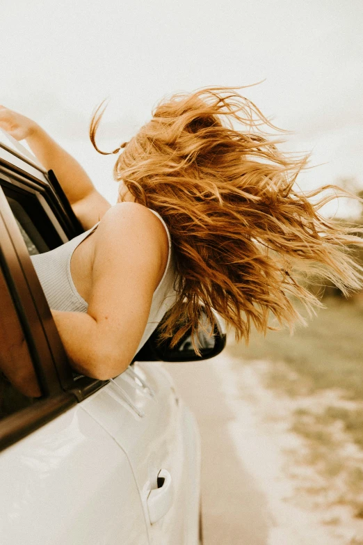 there is a woman sitting in the side mirror of a car