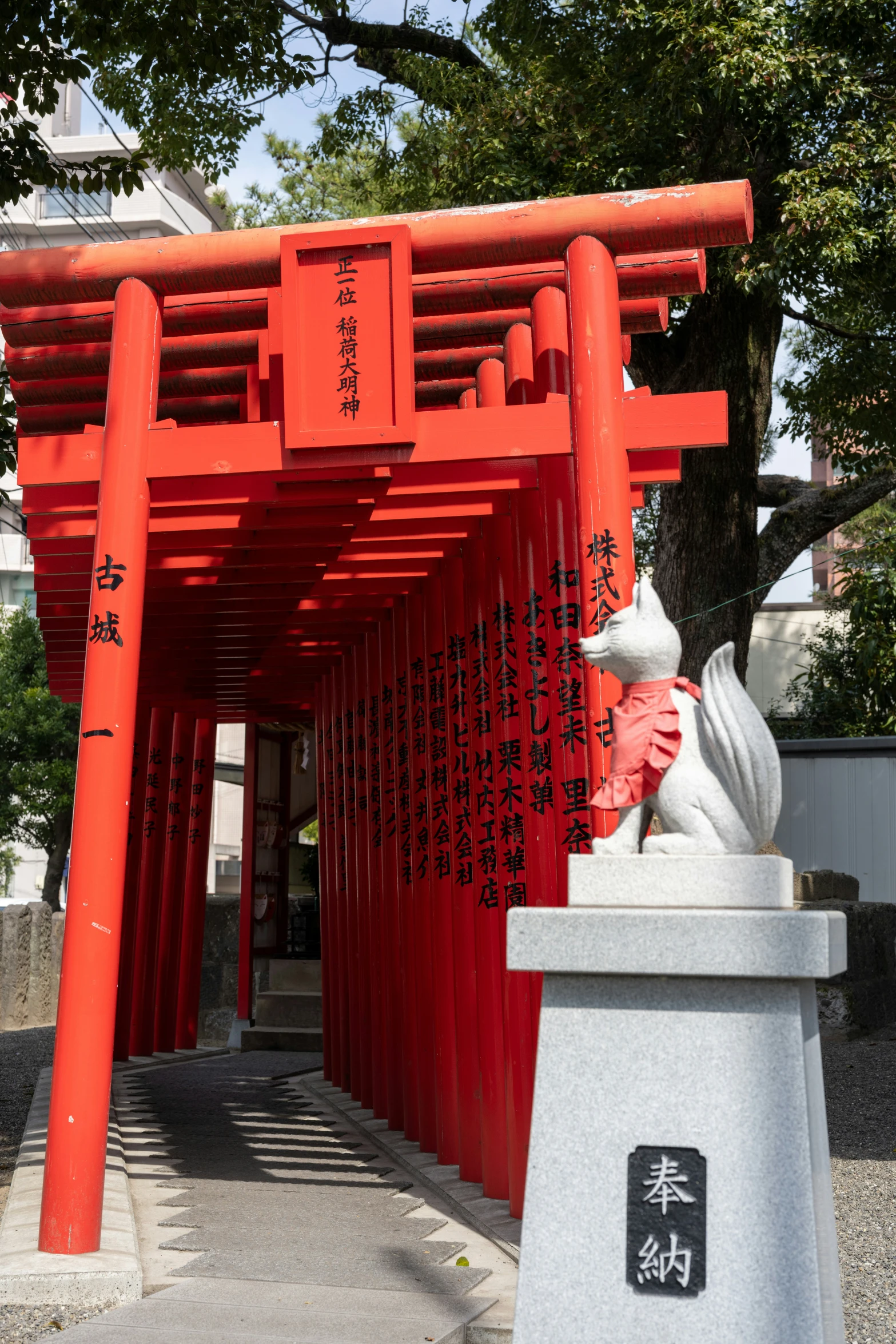 the pagoda has red and orange sculptures of dog and cat