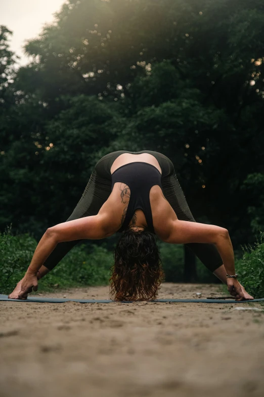 a woman doing yoga in the middle of the woods