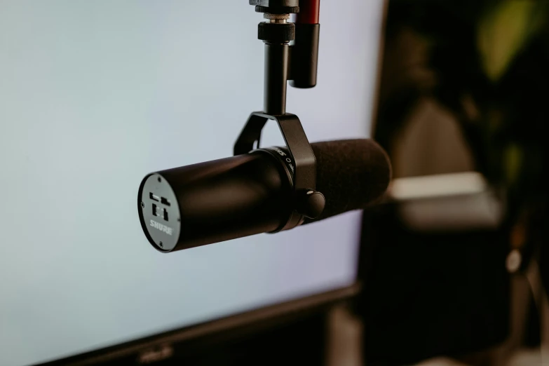 a microphone hanging next to a computer monitor