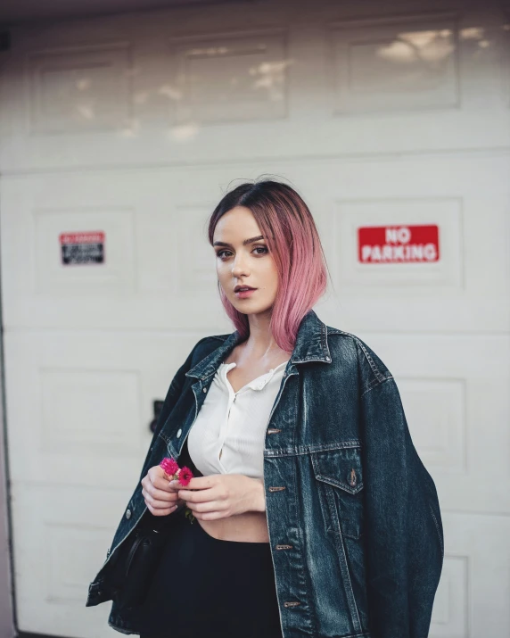 woman with pink hair and cropped white top holding a rose