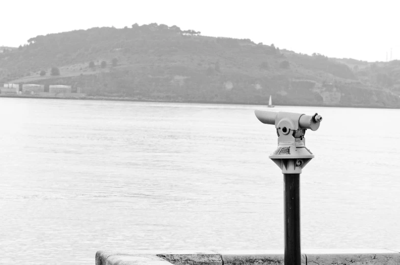 an old fashioned water hydrant in front of a lake