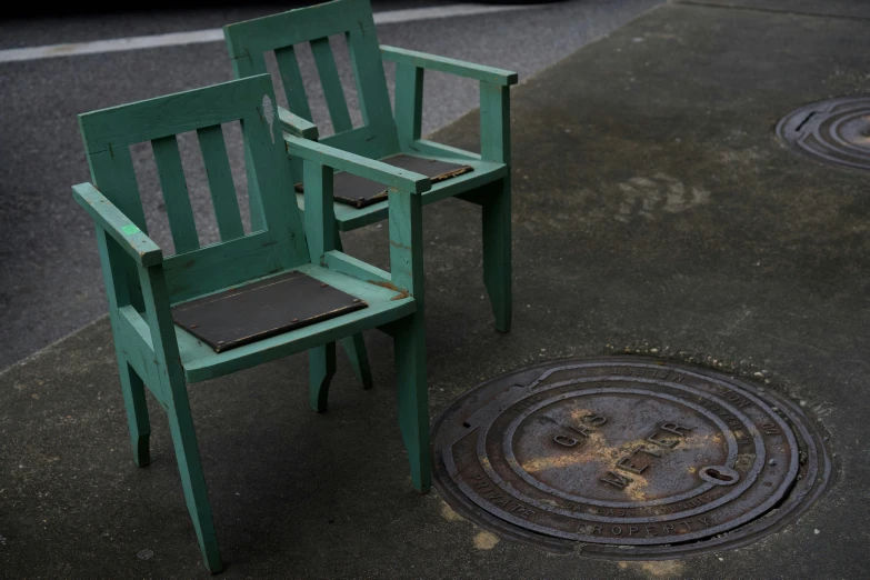 the two green chairs are by the drain