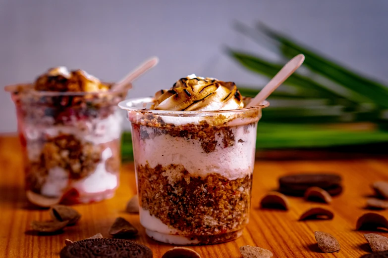 desserts placed on wooden table, with candy, nuts and whipped cream