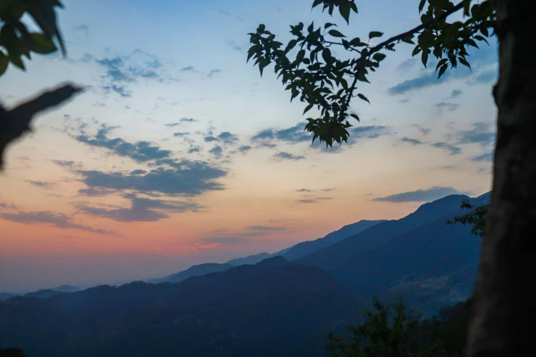 a dusk sky over a mountain with trees