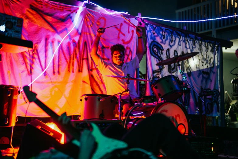 the man is playing his drums in a dark room