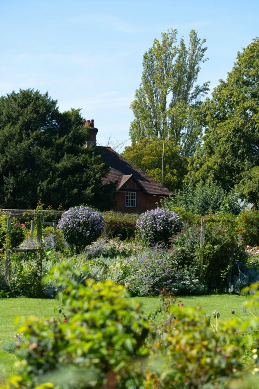 a park bench sitting in front of a house and shrubs