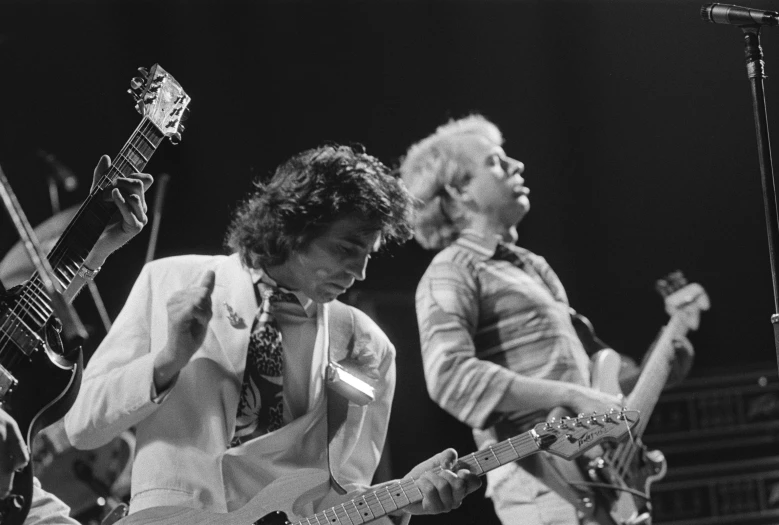 the group performs on stage in black and white