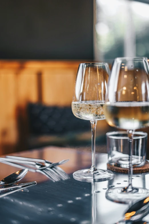 three wine glasses and plates on a table