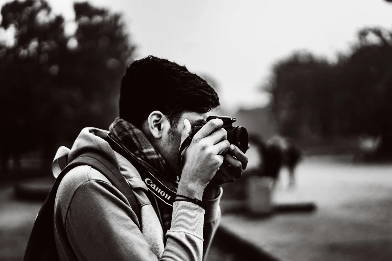 a person taking pictures with a camera near some trees