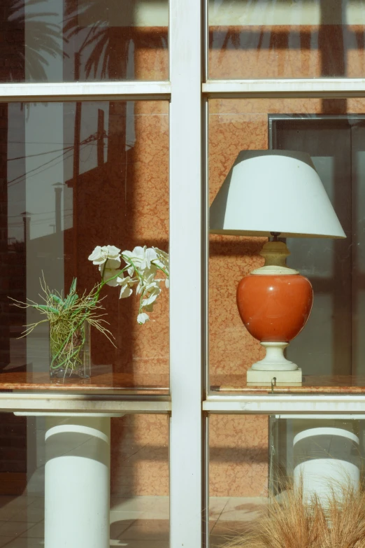 a small vase with flowers and a lamp