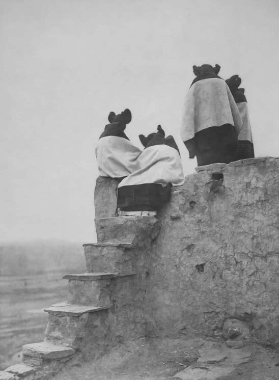 black and white po of three people sleeping on top of an old house