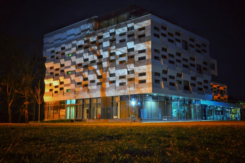 an office building sits next to grassy area in the dark