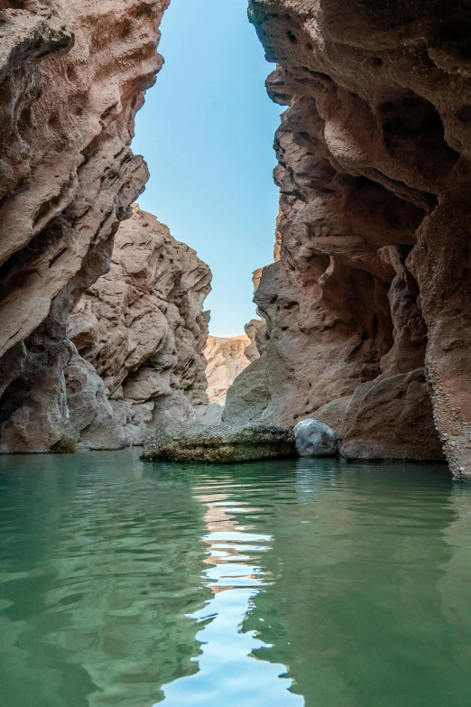 looking up at some water coming from between rocks