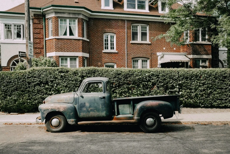 an old pick up truck parked on the side of the street