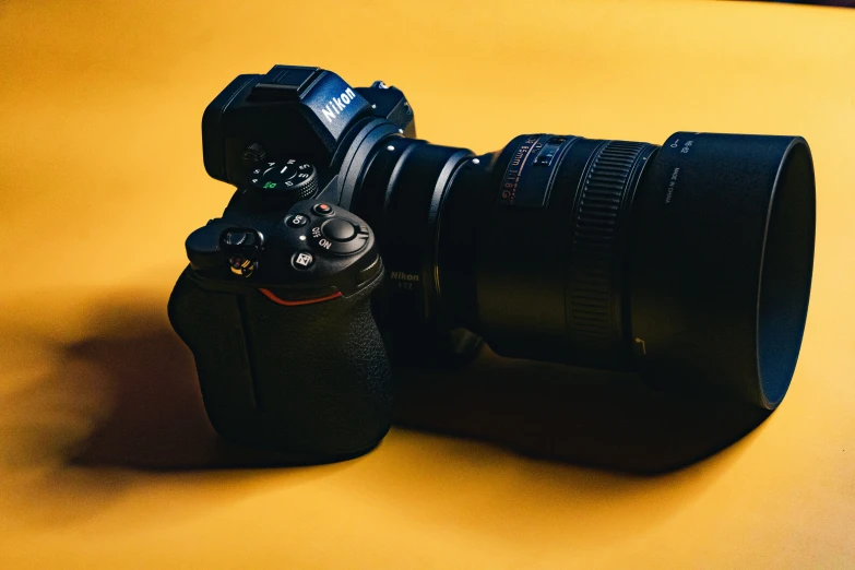 a camera and its lens bag are pographed against a yellow background