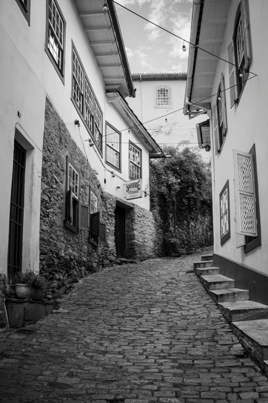 the cobblestone road is empty and has many windows