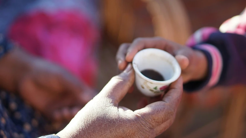 a man holding onto two empty cups