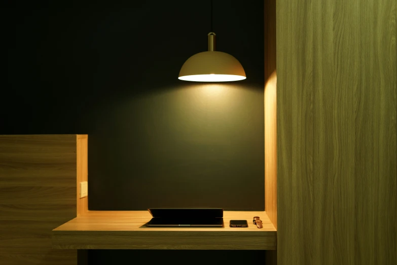 lamp over the desk in front of a black wall