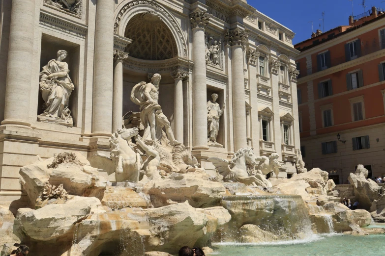 a beautiful fountain surrounded by people and statues