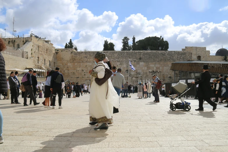 a man standing outside while other people gather around