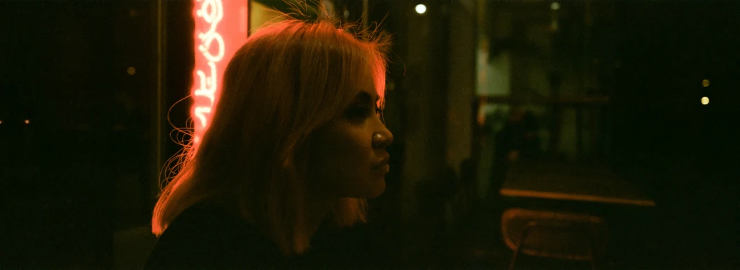 girl standing in front of a neon light