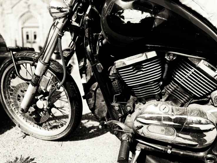 black and white pograph of motorcycle parked in a parking lot