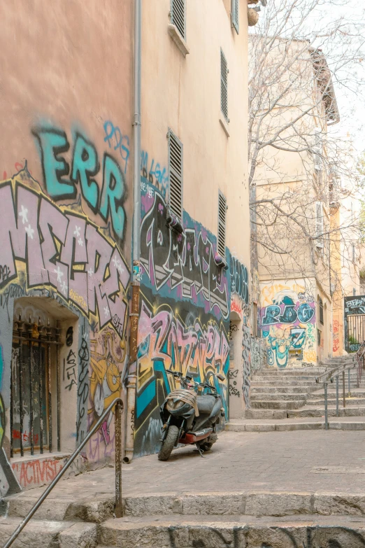 a motorcycle is parked beside a building and graffiti