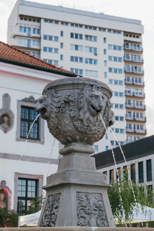 a large cement planter with water coming out of it