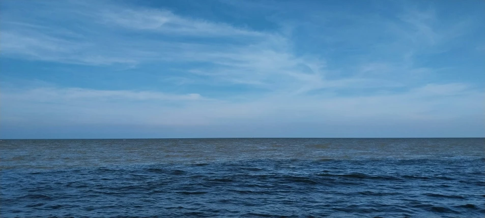 the water with a few clouds is blue