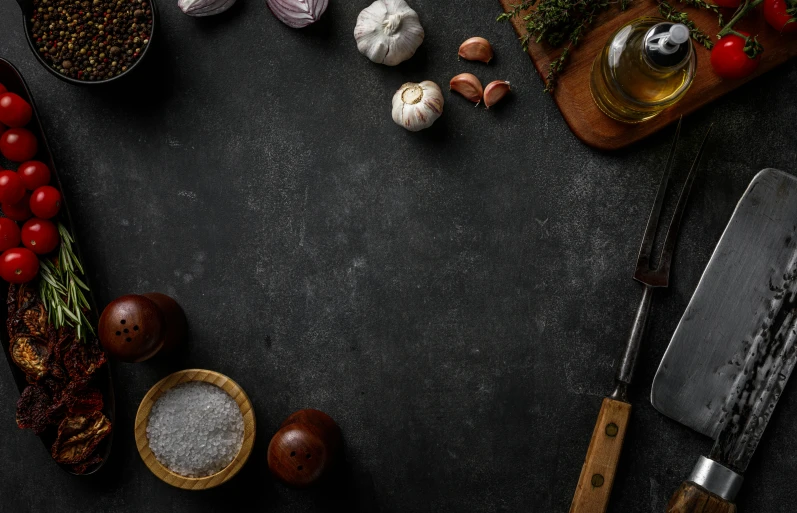 various ingredients on a dark table including a knife and peppers