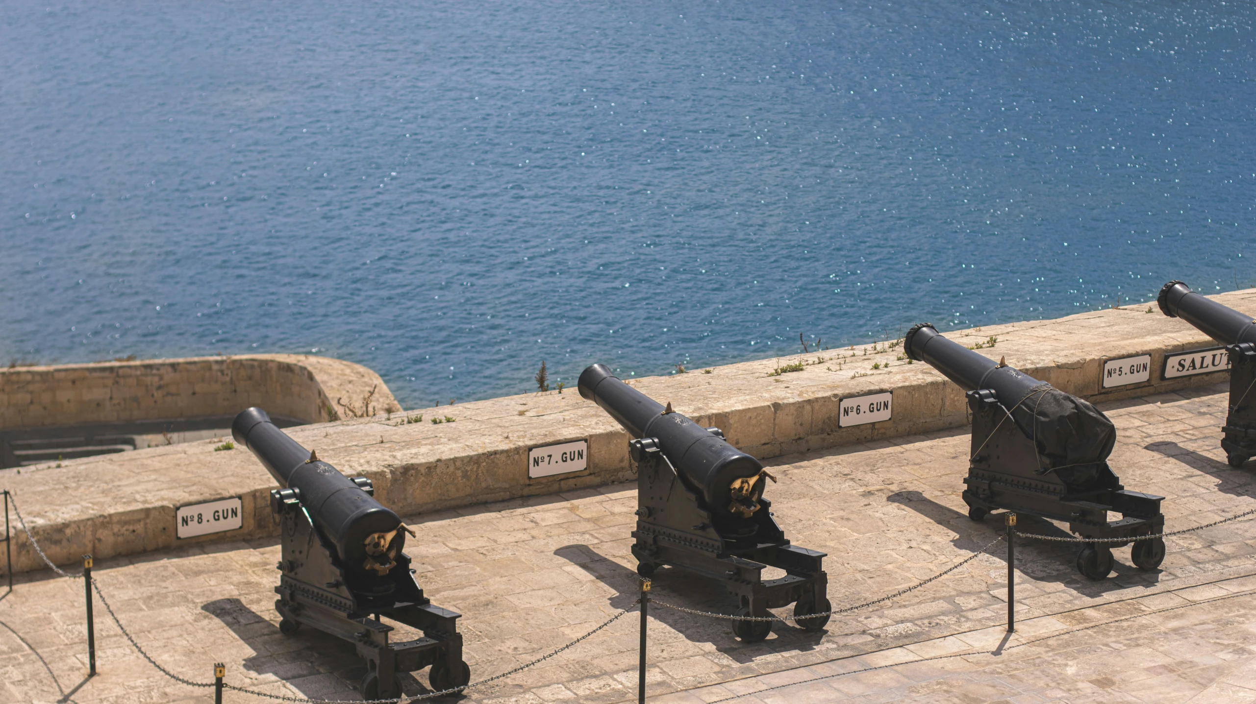 four large weapons sitting on top of a cement surface