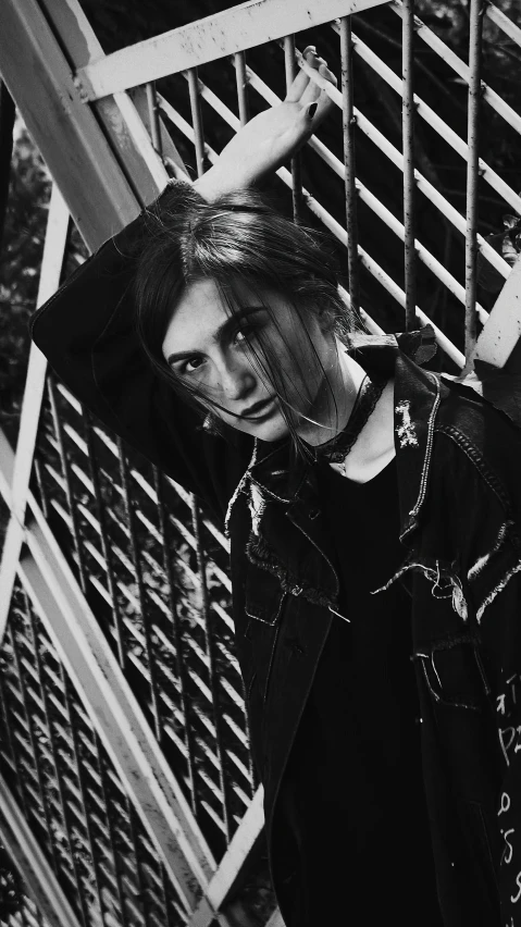 young woman with long hair leaning against fence