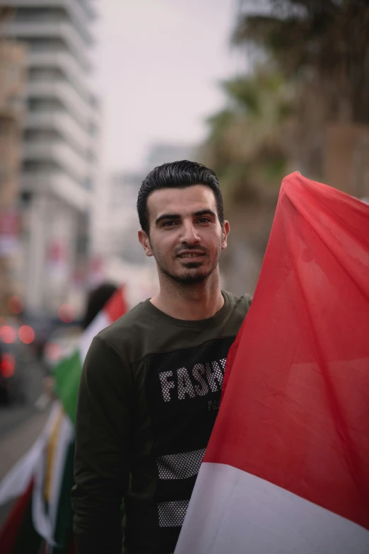 a man poses with his arms around the side of the flag