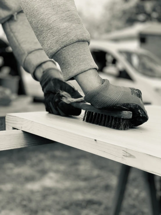 a person in gray sweater  wood with a brush