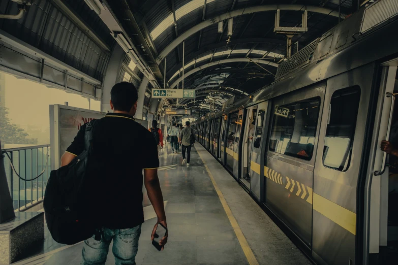 the man is approaching the subway on the platform