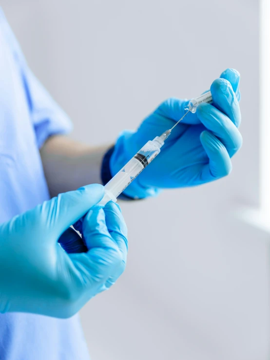 a person in scrubs holding onto a medical instrument