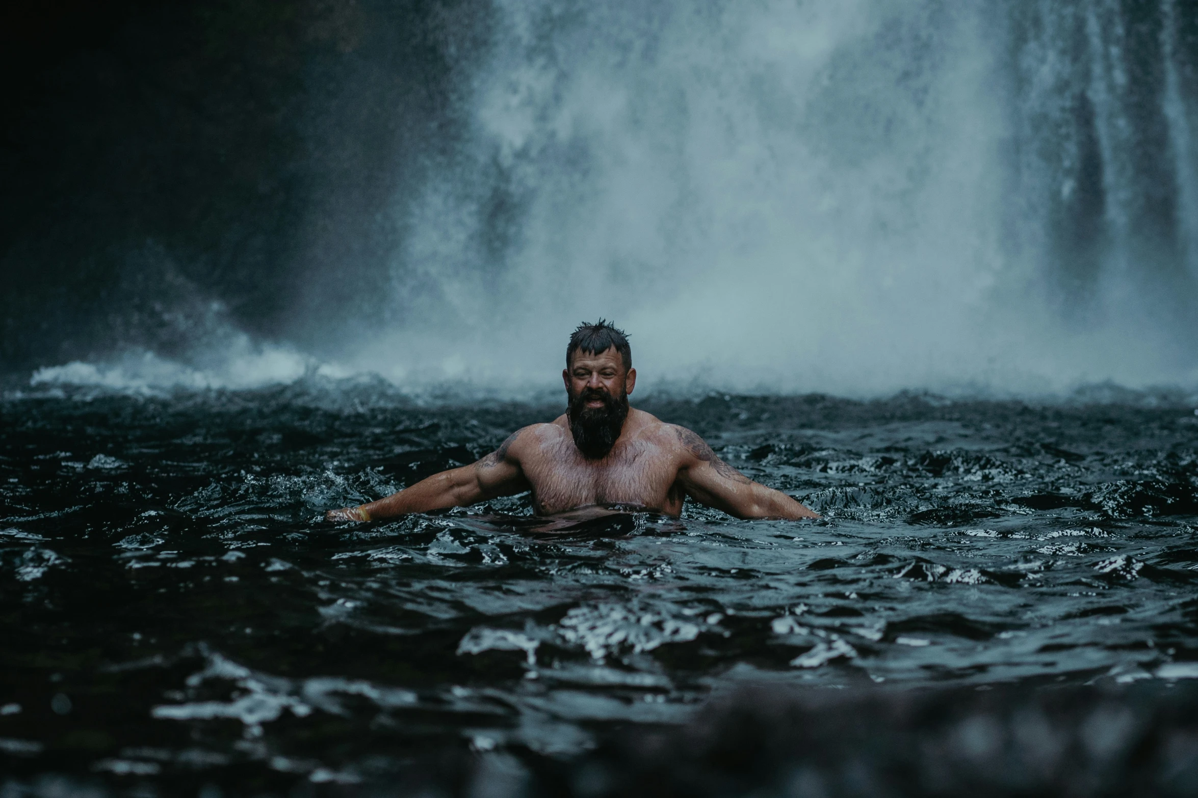 a man swimming in the middle of a body of water