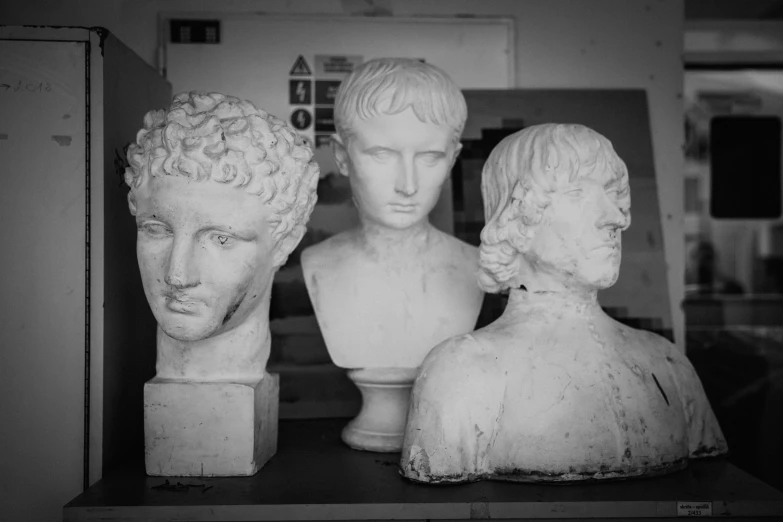 a black and white po of three busts