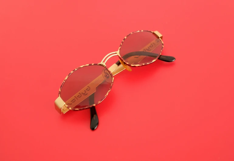 a pair of red glasses with black frames on a red background