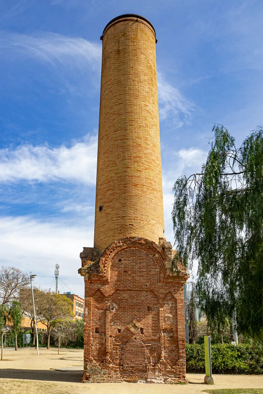 there is a brick tower near a park