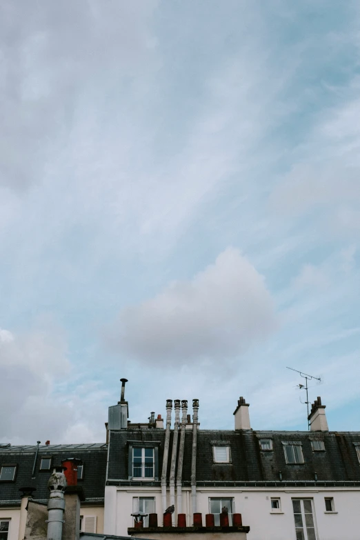 a white and black house that is under a cloudy sky