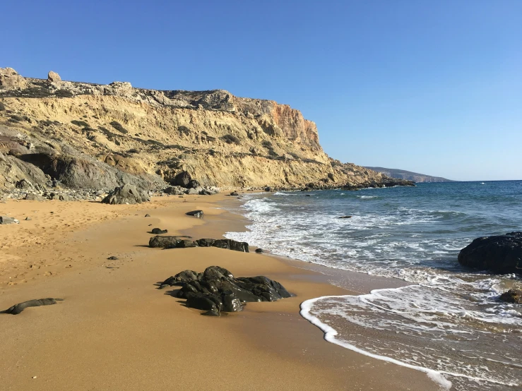 an ocean shoreline, with large rocks on either side