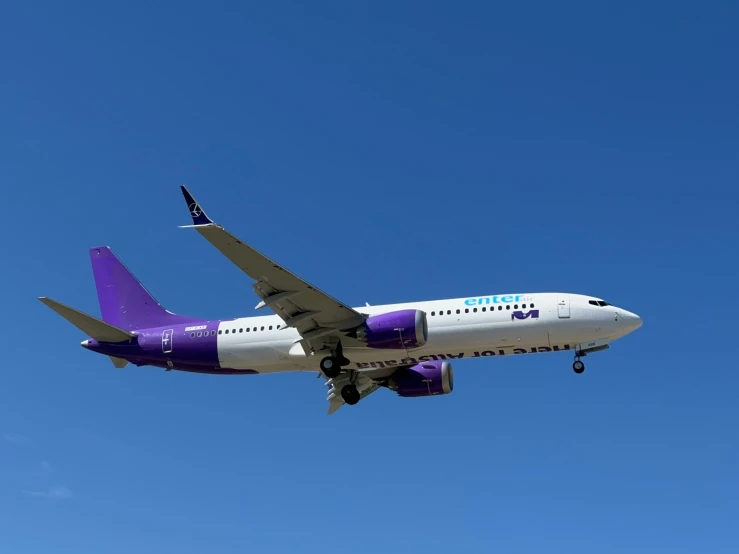 a large passenger jet flying through a bright blue sky