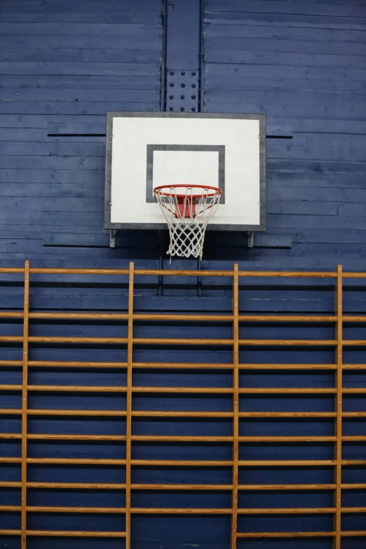 a basketball hoop suspended in front of a blue wall