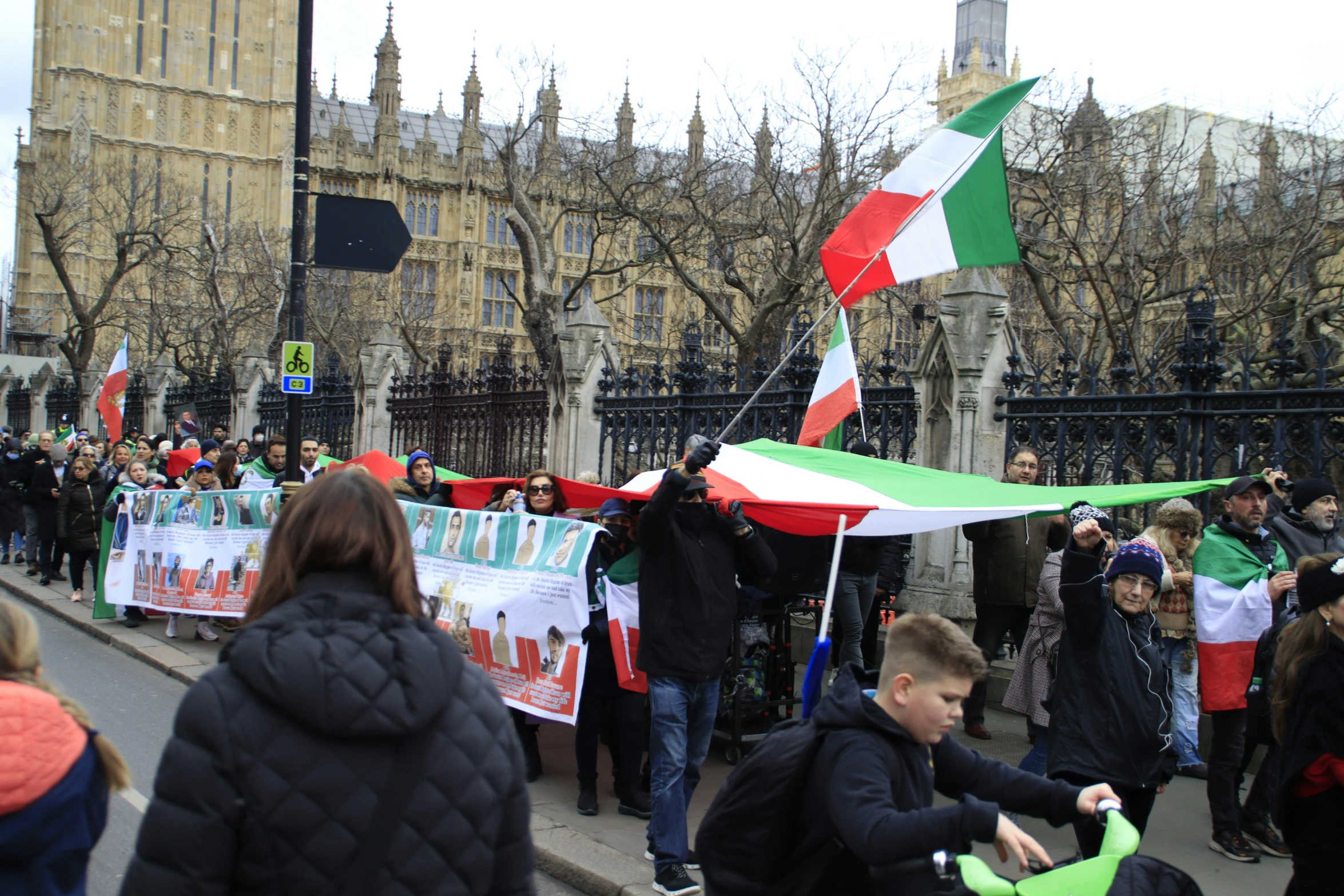 the people on the side walk are holding banners